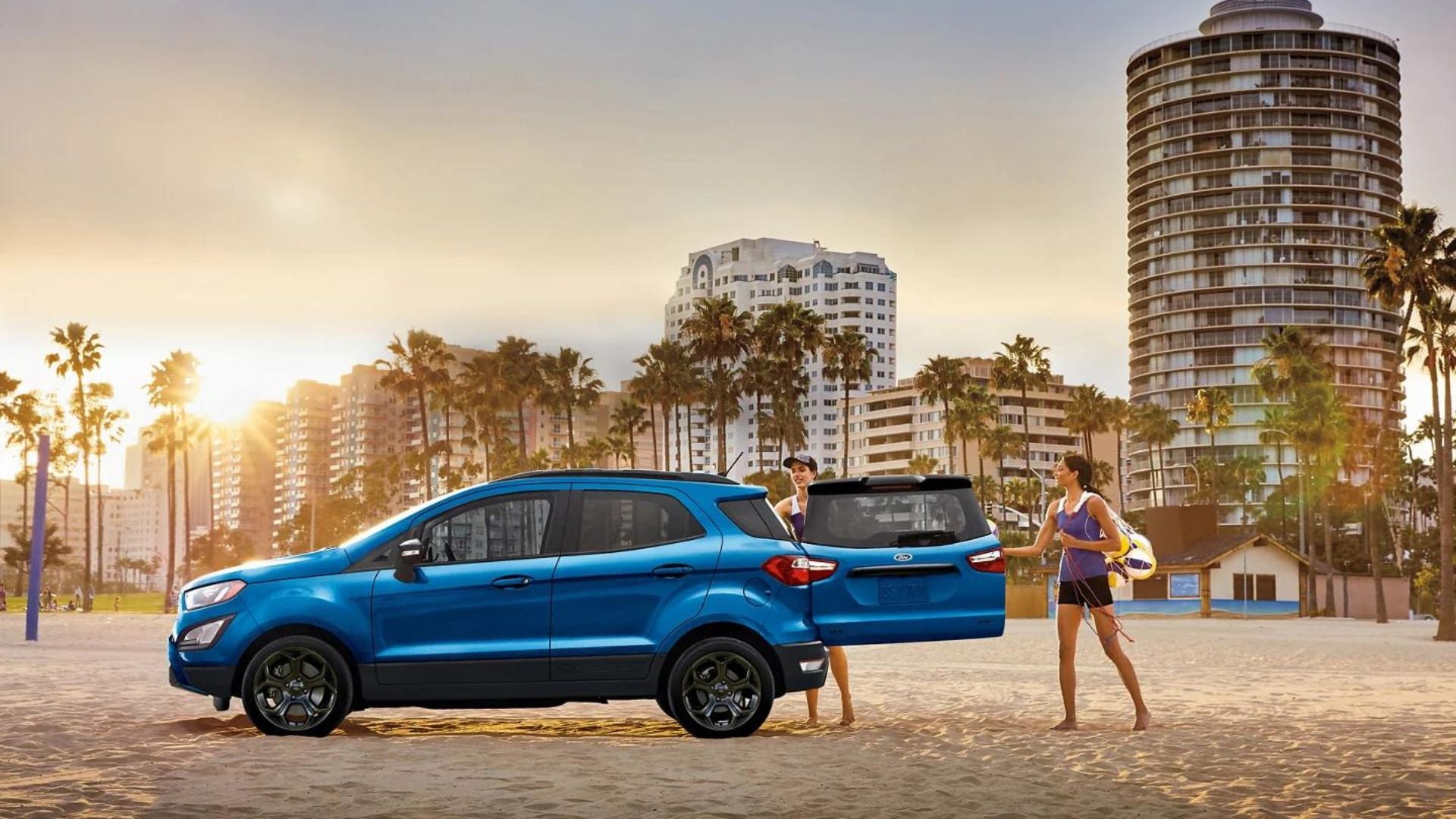 2022 ford ecosport se on the beach with two people unloading stuff from the rear trunk of the vehicle